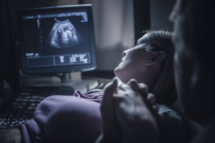 A woman looking at the screen during an ultrasound.