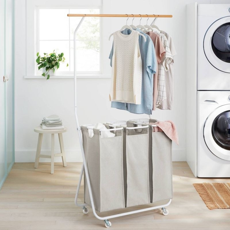 the white and tan laundry sorter next to a washer and dryer