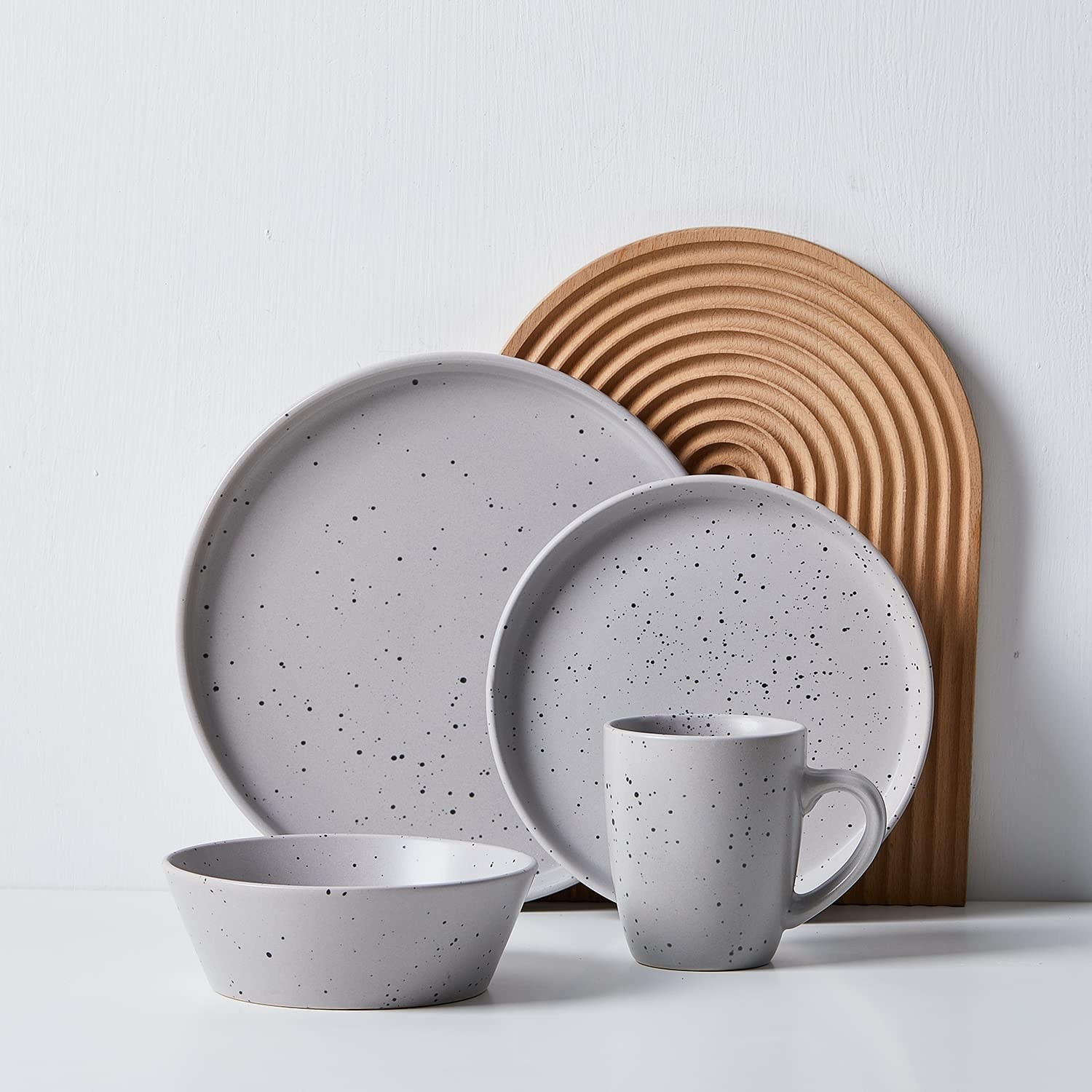 a speckled dinnerware set arranged artistically on a plain countertop