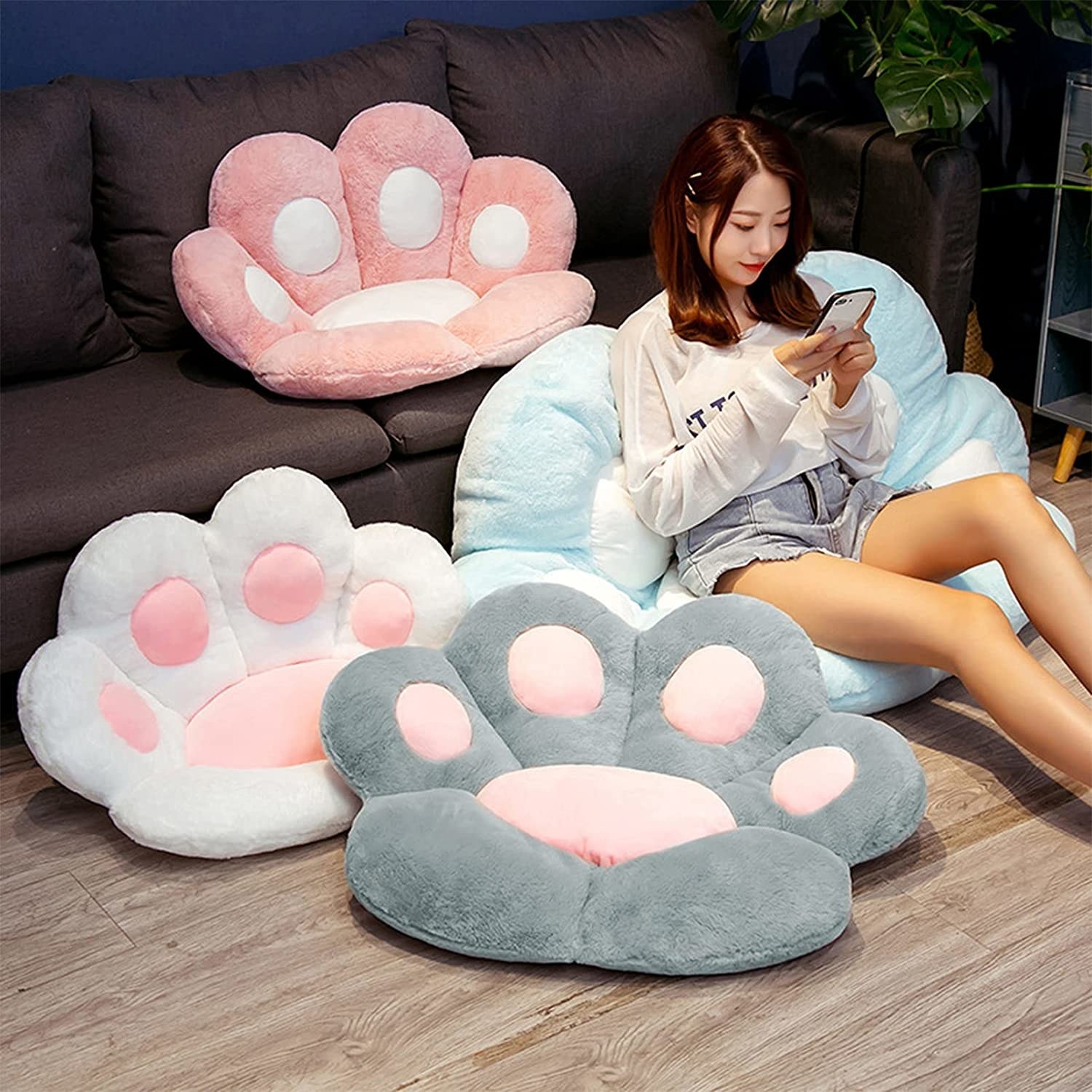 a person sitting on a large cushion shaped like a cat&#x27;s paw