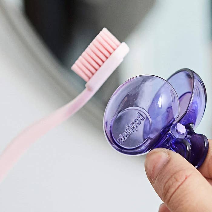 A person placing the clip-on cover over their toothbrush