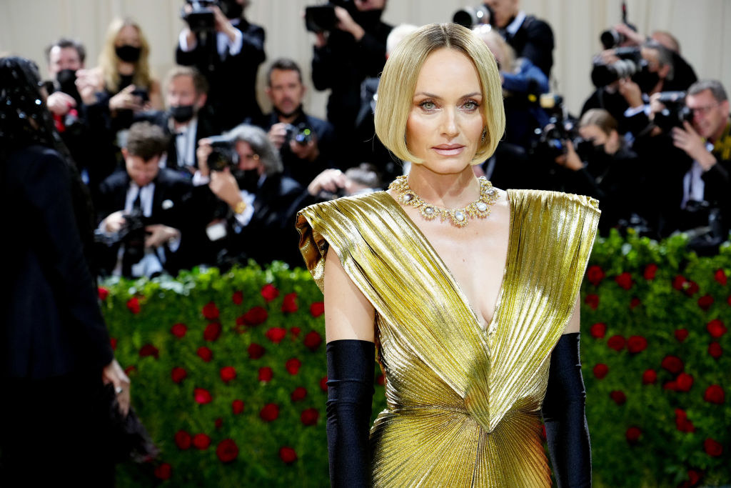 A closeup of Amber Valletta wearing the gold dress