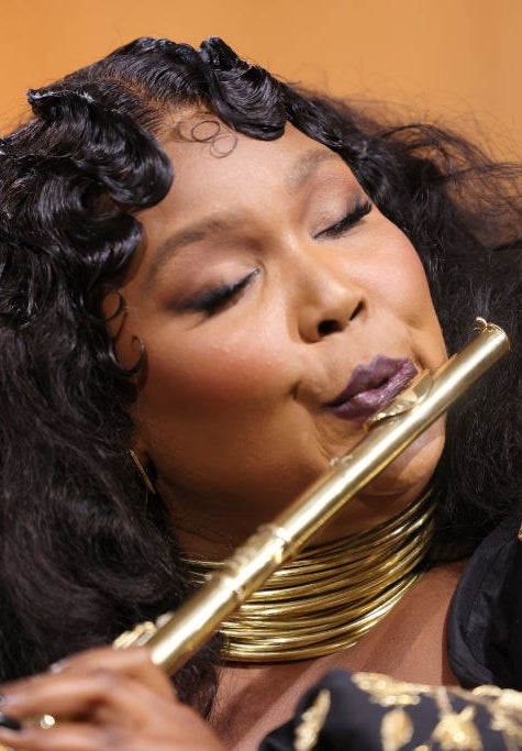 Lizzo playing a gold flute