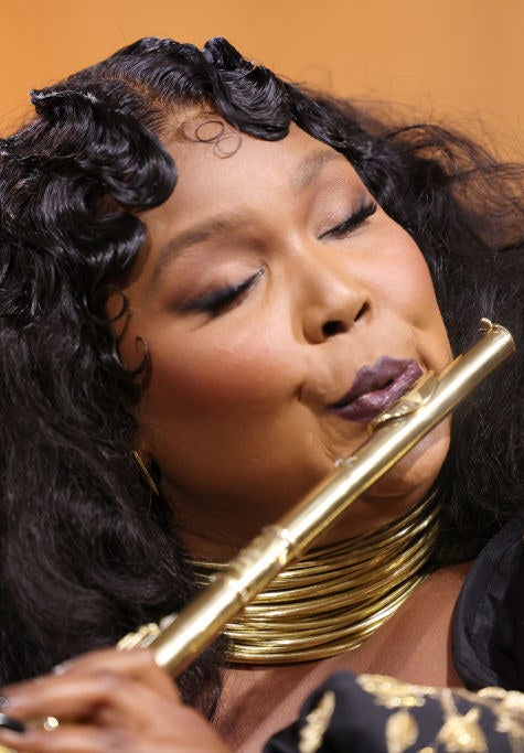 Lizzo playing a gold flute