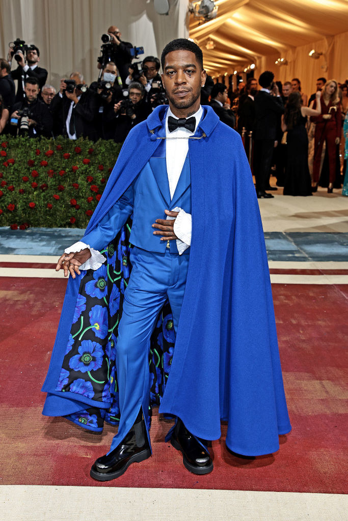 Kid Cudi on the red carpet showing off the floral design on the inside of the cape