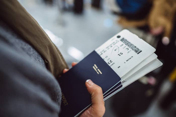 close up of someone holding their passport with their tickets inside