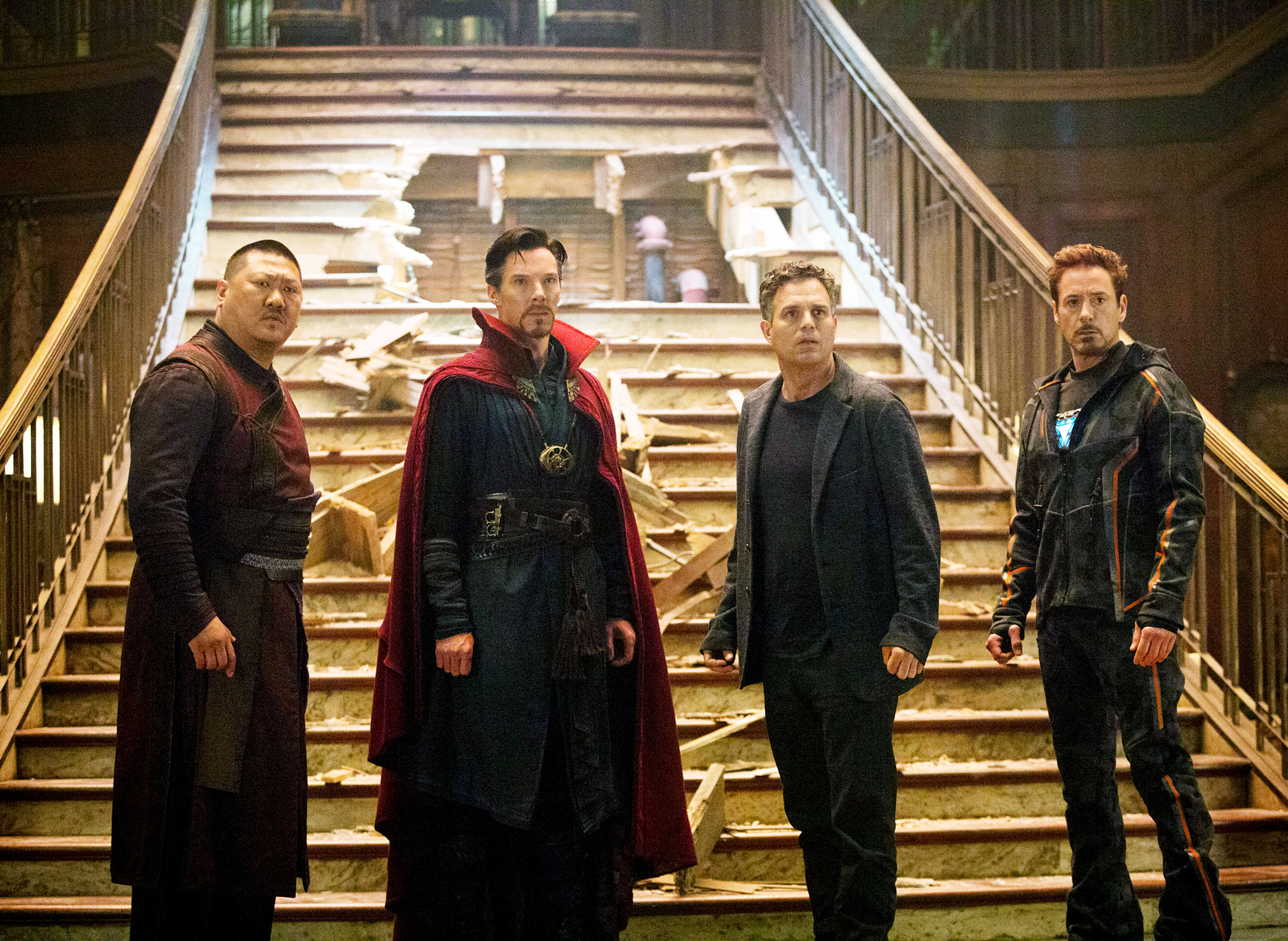 Four Avengers stand by a broken staircase