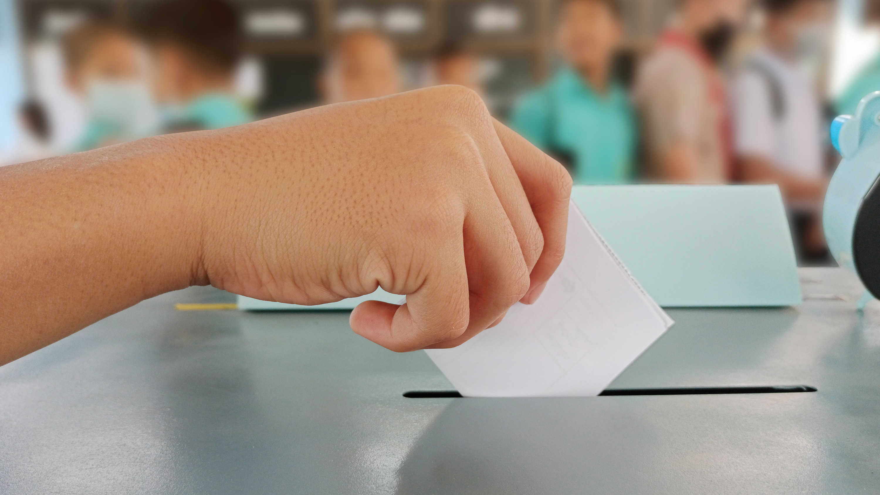 学生的手在一个投票箱投票的地方