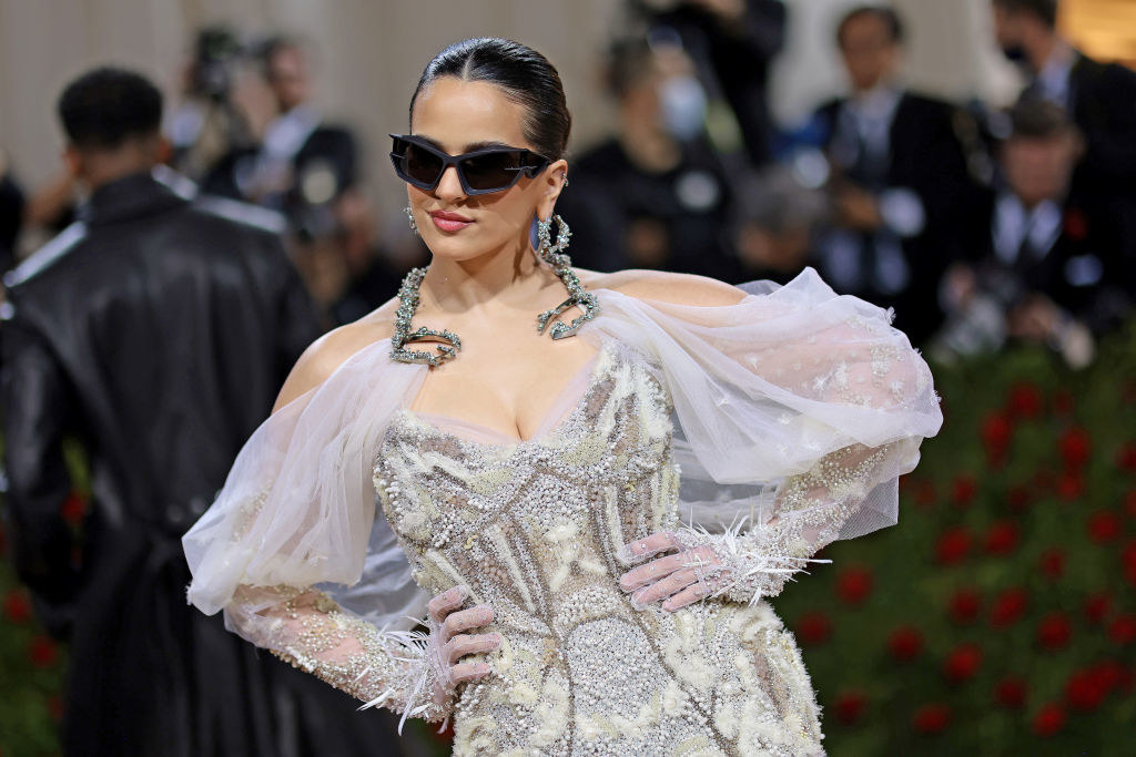 Rosalía in an embellished dress with draped sleeves, gloves, and sunglasses