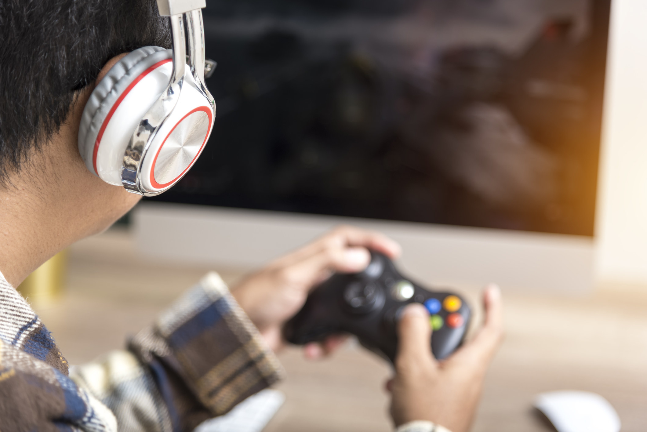A man with headphones on playing video games.