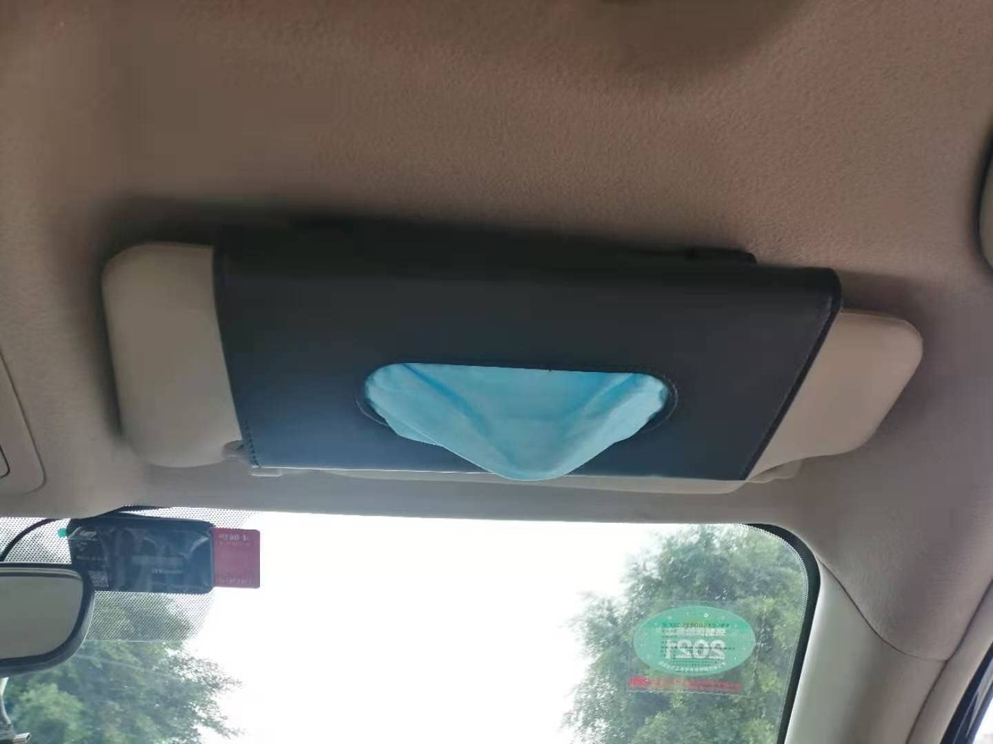 A leather tissue holder clipped to a car sun visor
