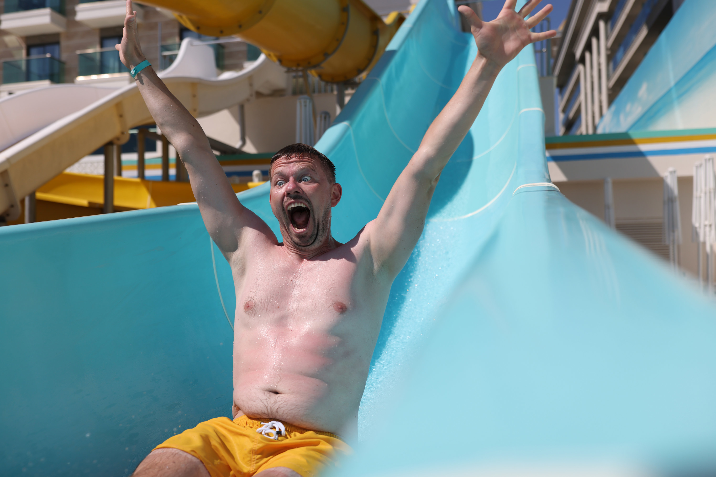 A happy man slides down a water slide