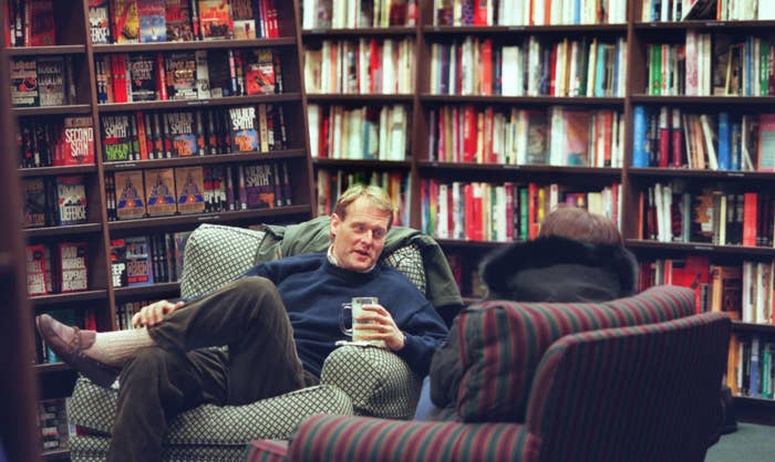A man relaxing and chatting with someone while sitting in an old chair in Barnes &amp;amp; Noble