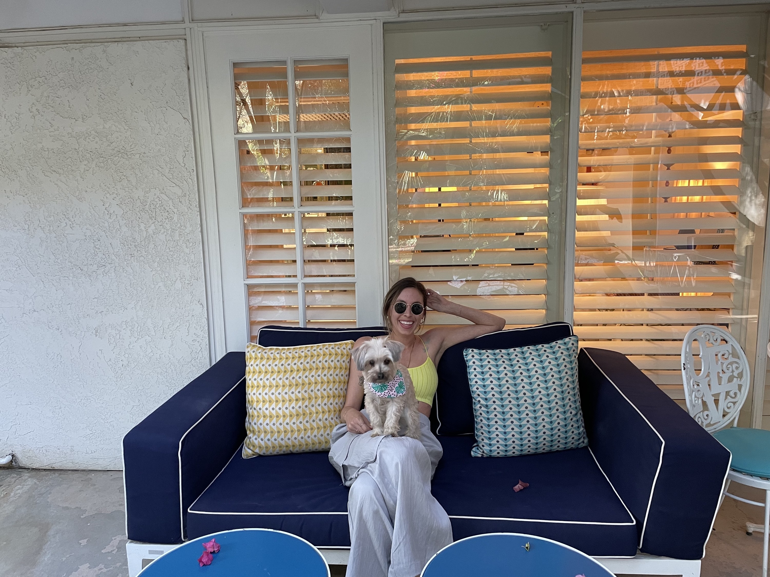 The author sitting on the patio with her dog, Pepper, on her lap