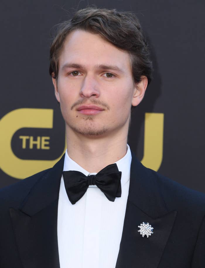 Ansel smiles for the camera while wearing a tux and a mustache