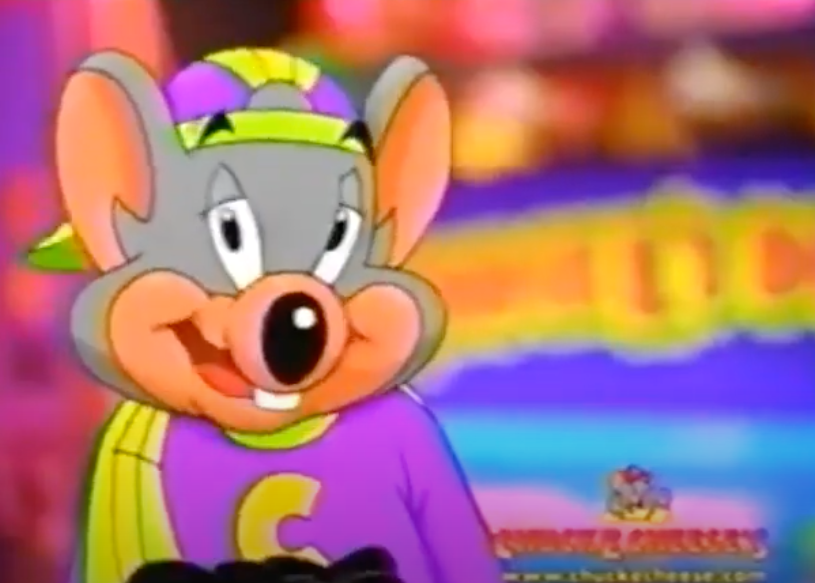 An animated Chuck E. Cheese mascot wearing a backward hat