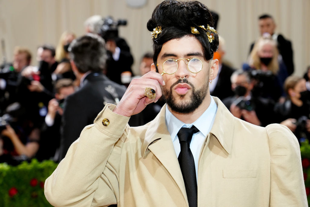 Close-up of Bad Bunny holding lorgnette spectacles to his face