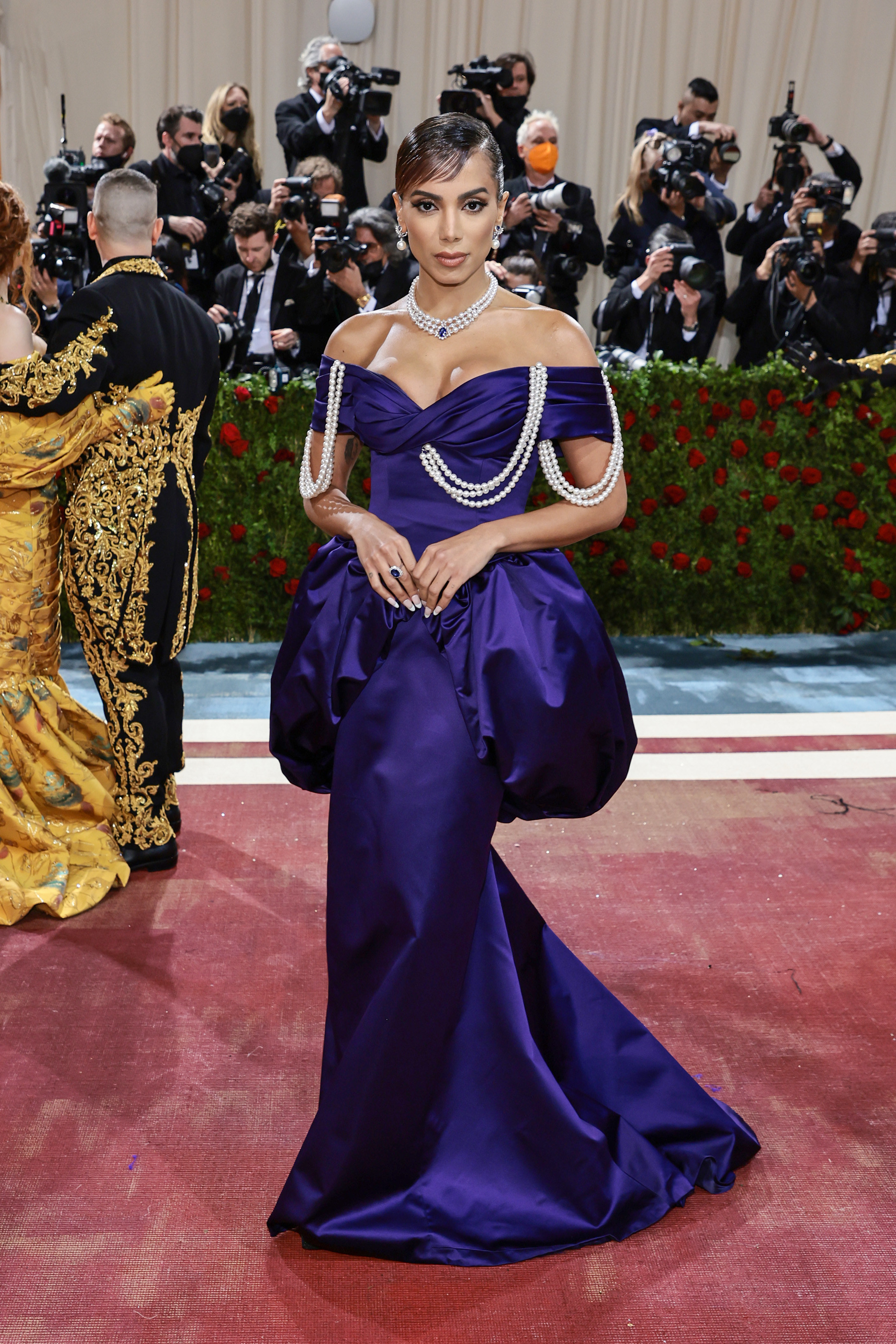 Anitta on the Met Gala steps in an off-the-shoulder satiny gown with pearl accents
