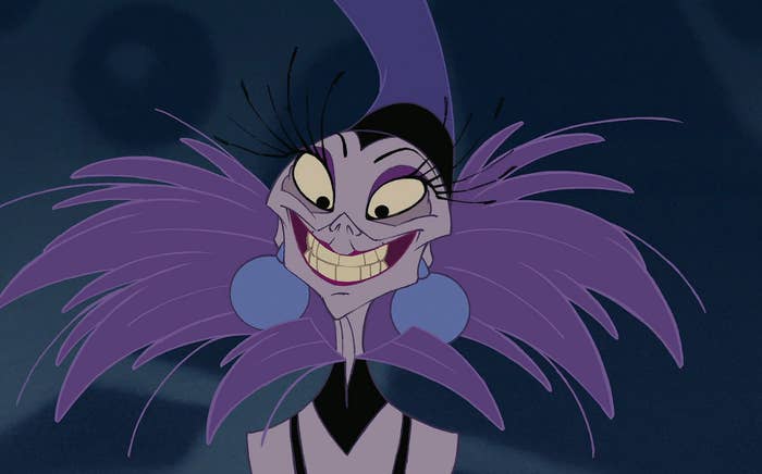 A close up of Yzma as she smiles while wearing a dress with a large feather collar