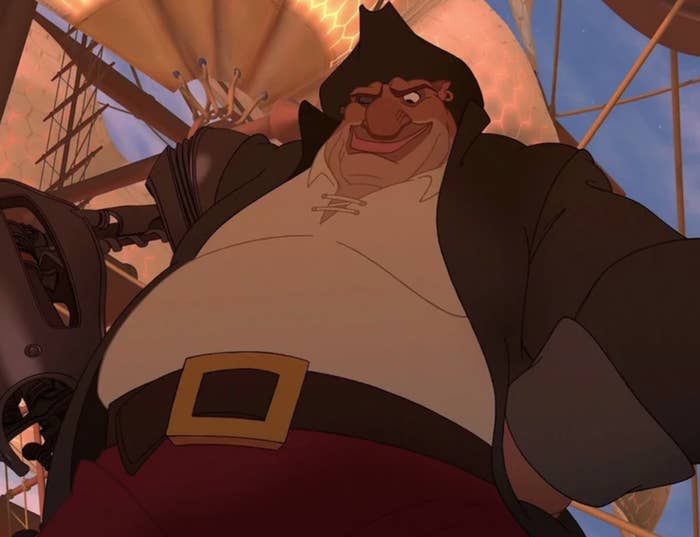John Silver looks down at someone while standing with his hands on his hips