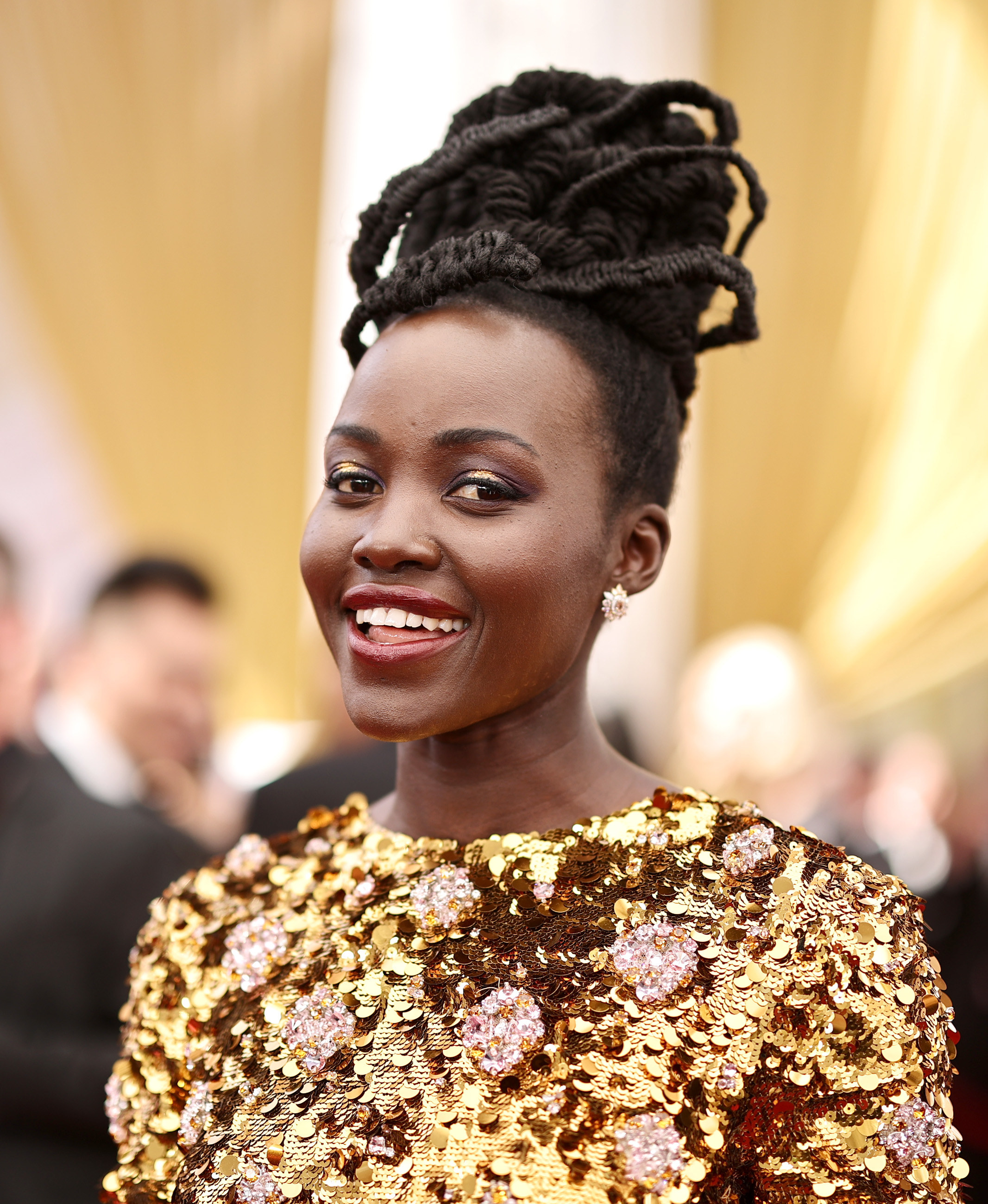 Lupita Nyong’o in a gold dress at an event