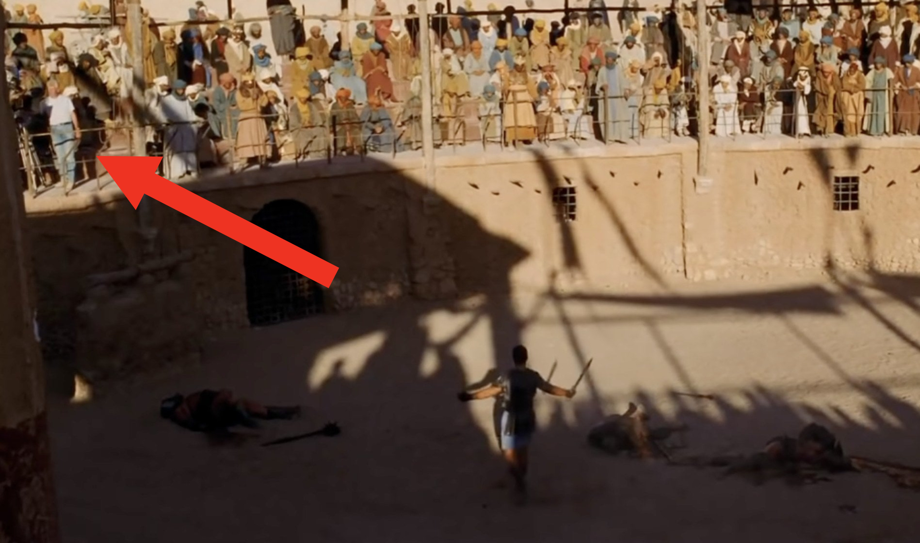 A scene from Gladiator with a crew member in modern-day clothes in the shot