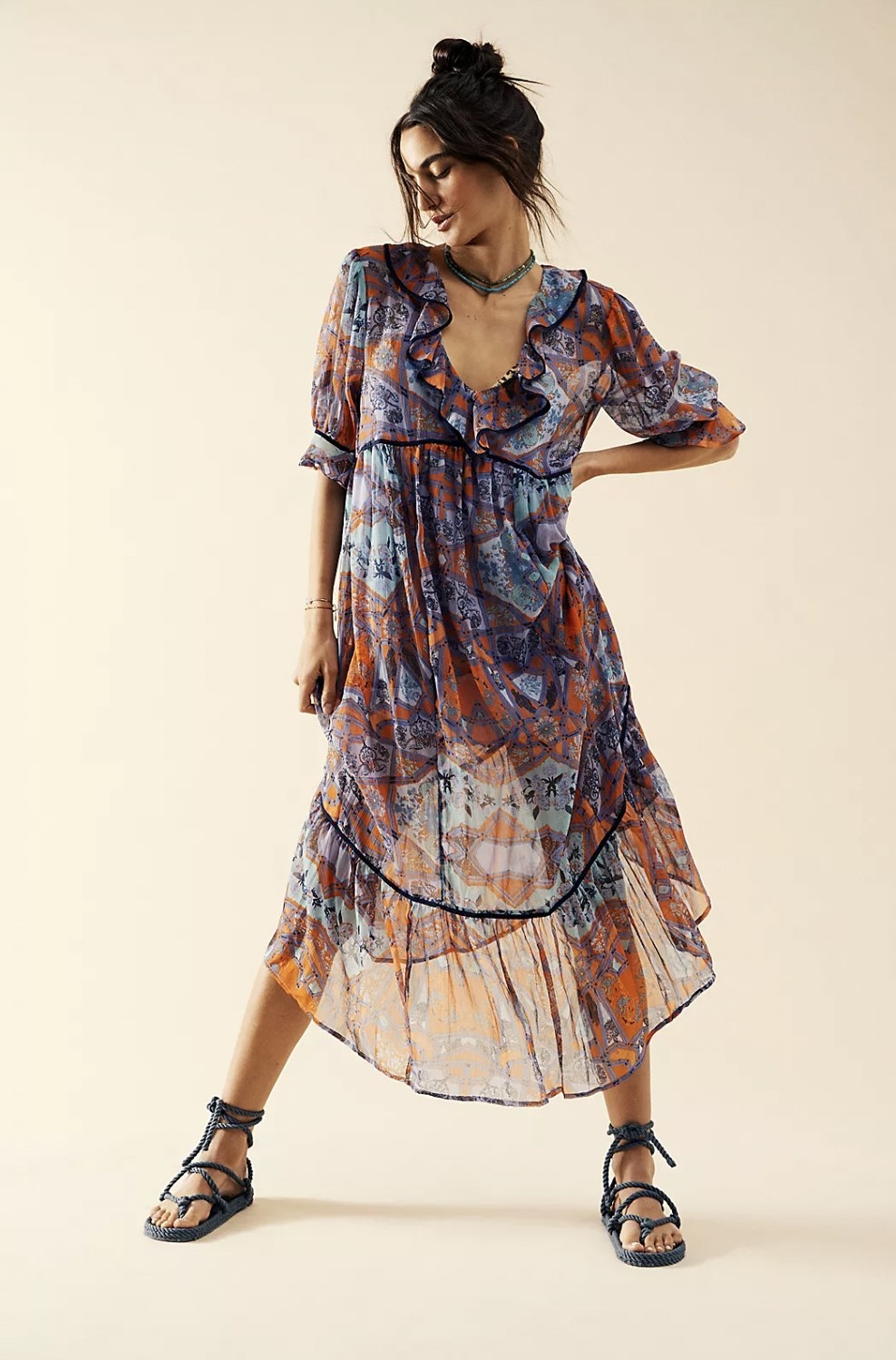Model in the purple and orange patterned midi dress featuring ruffle v-neck and flowy skirt