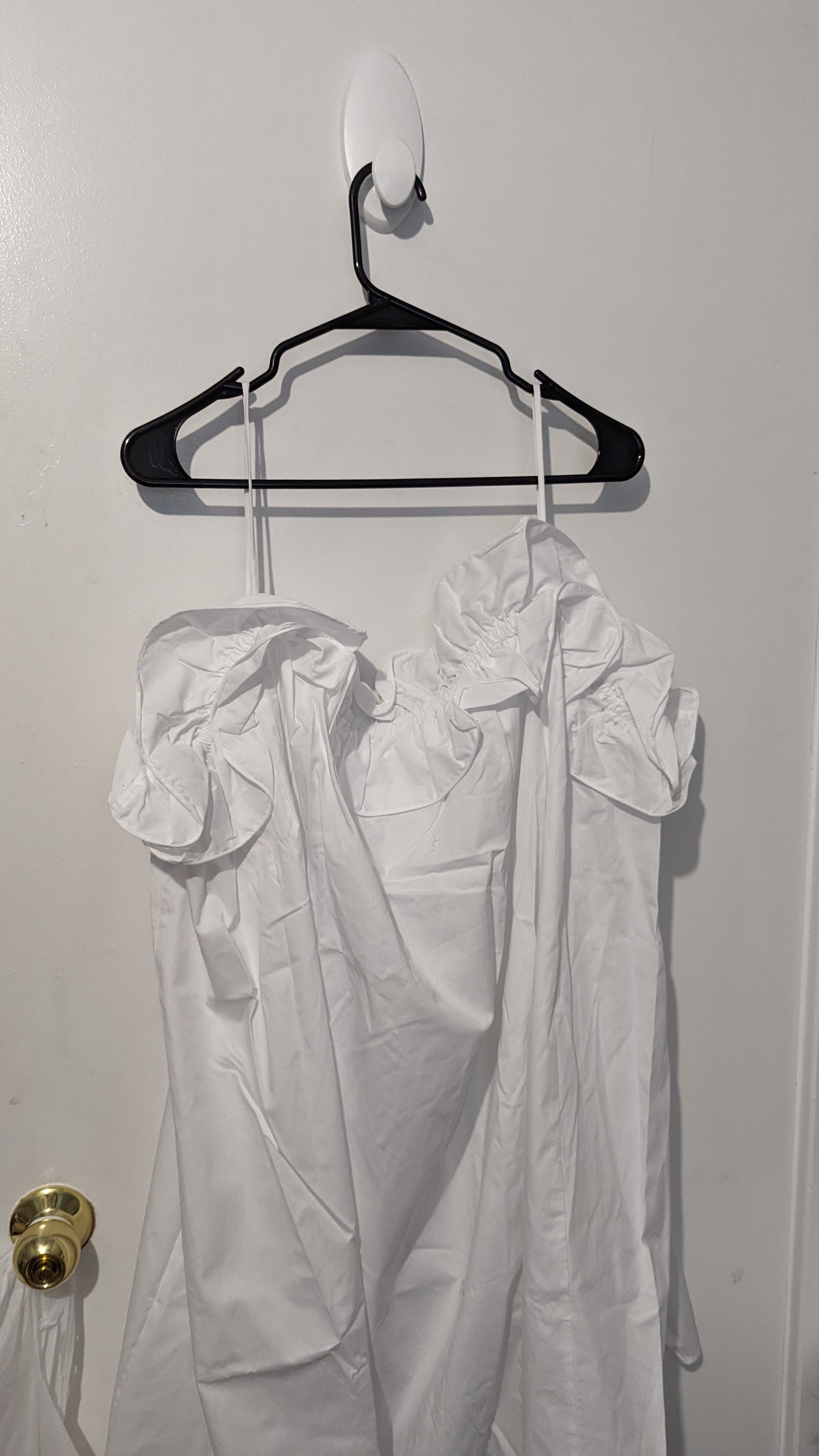 A spaghetti strap dress hanging from a hanger