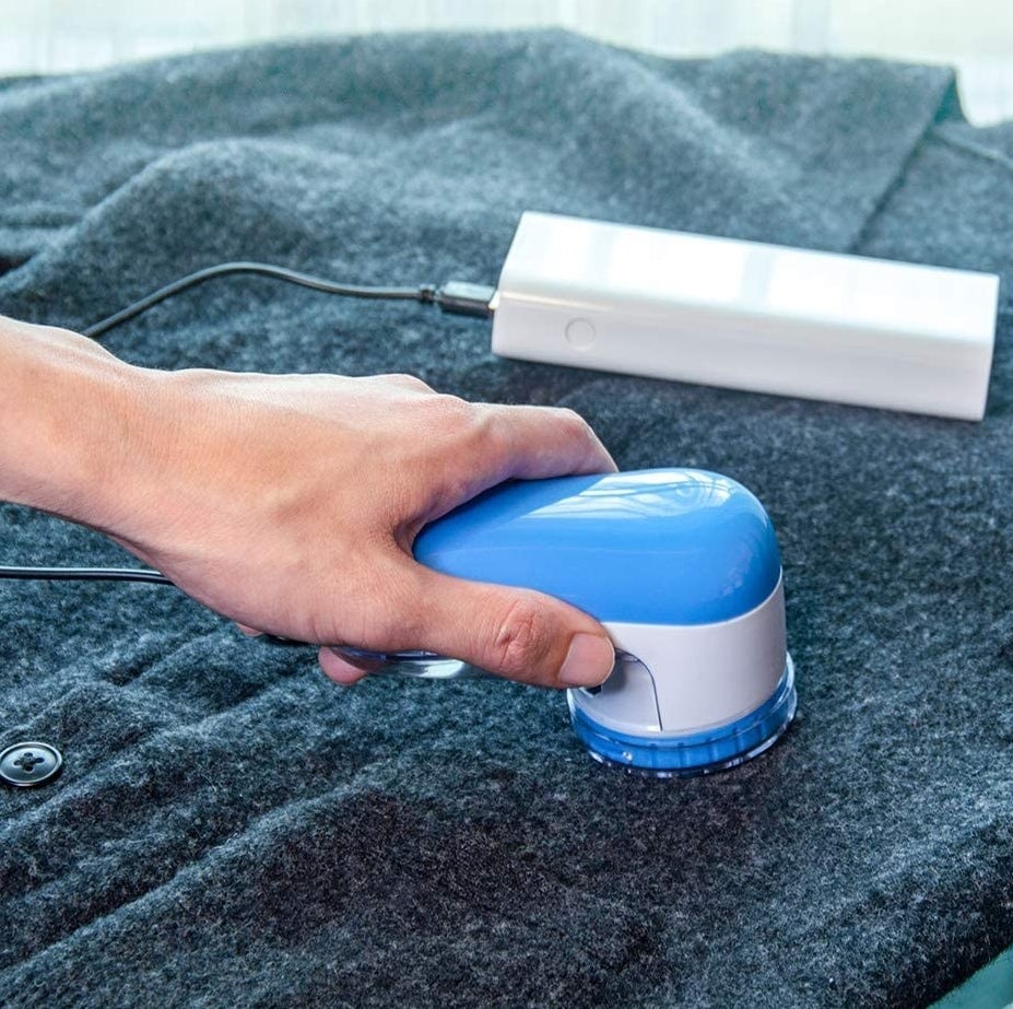 a person using the fabric shaver on a pilling sweater