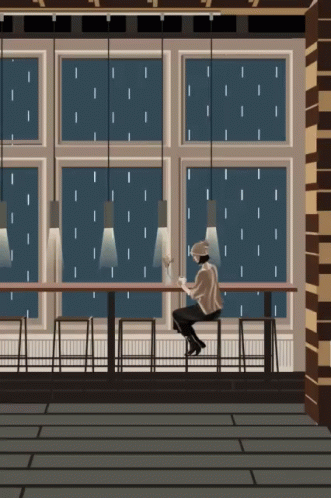 A GIF of someone sitting in a coffee shop alone while it&#x27;s raining outside