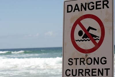 &quot;Strong current&quot; sign on a beach