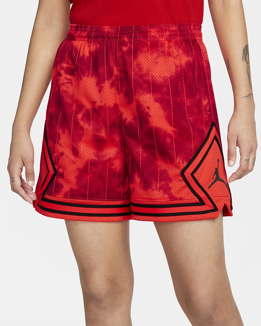 model in red tie-dye basketball shorts with a jordan logo on the sides