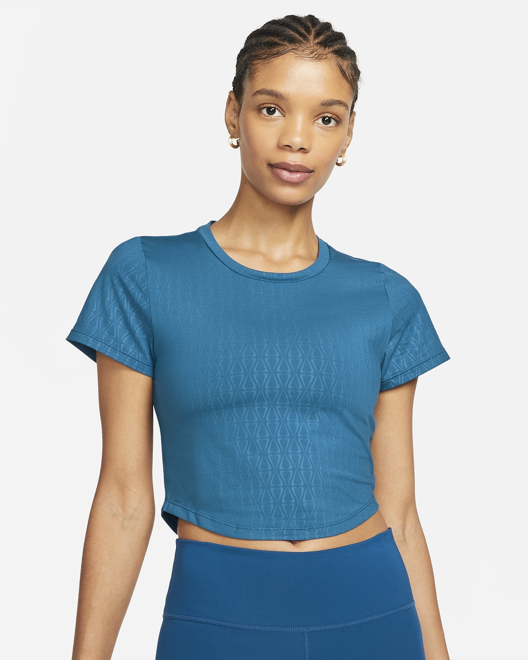 model in a blue cropped top with short sleeves and a curved hem