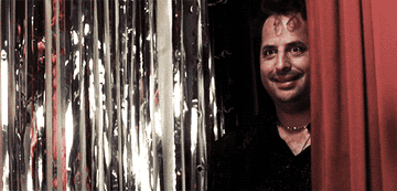 Jon Lovitz (in The Wedding Singer) behind a slowly closing red curtain