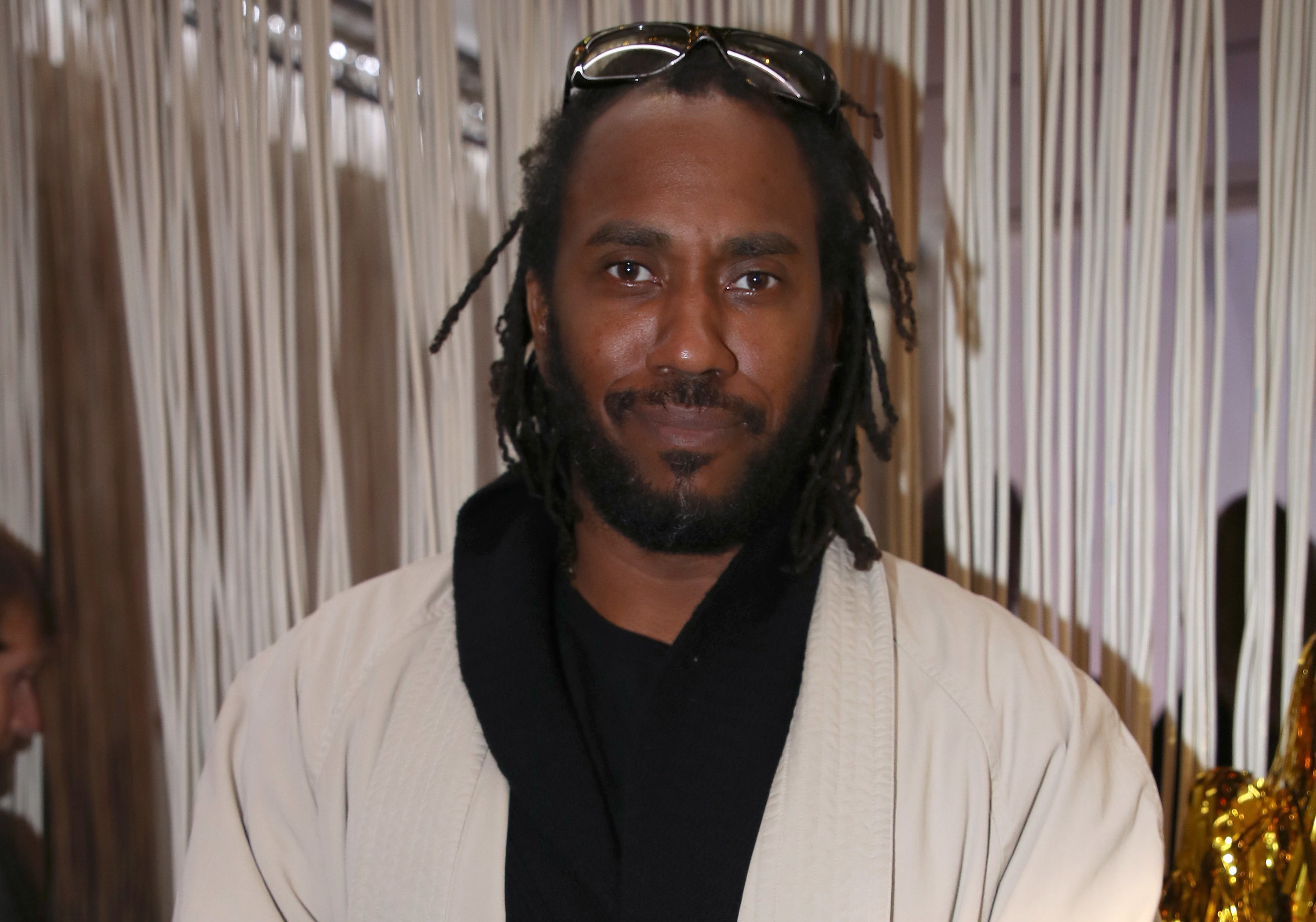 Rashid Johnson standing in front of hanging string at an art event