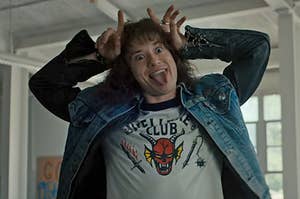 Eddie from Stranger Things positions his fingers like horns on his head