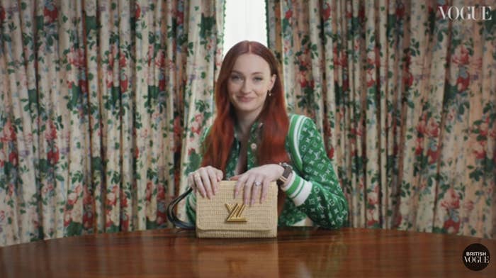 Sophie smiling while sitting at a table and holding a handbag