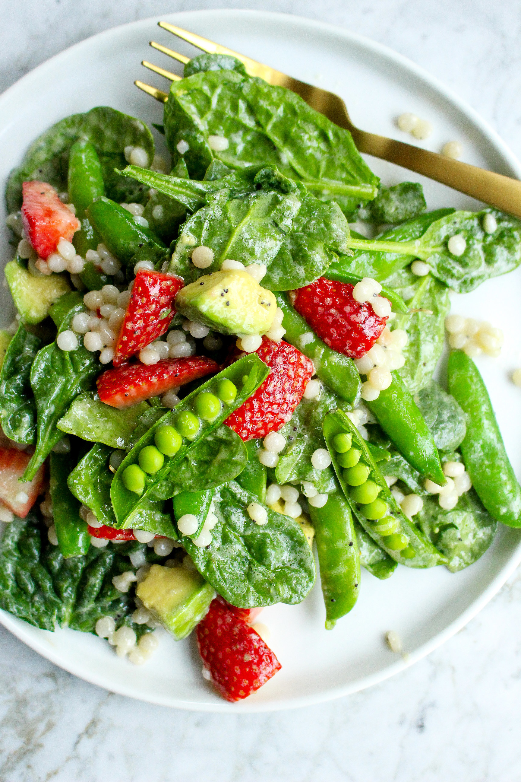 Couscous salad with avocado, strawberry, snap peas, and creamy dressing.
