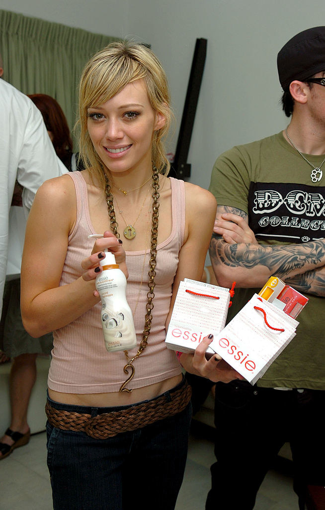 Hilary smiling and holding up Essie nail items