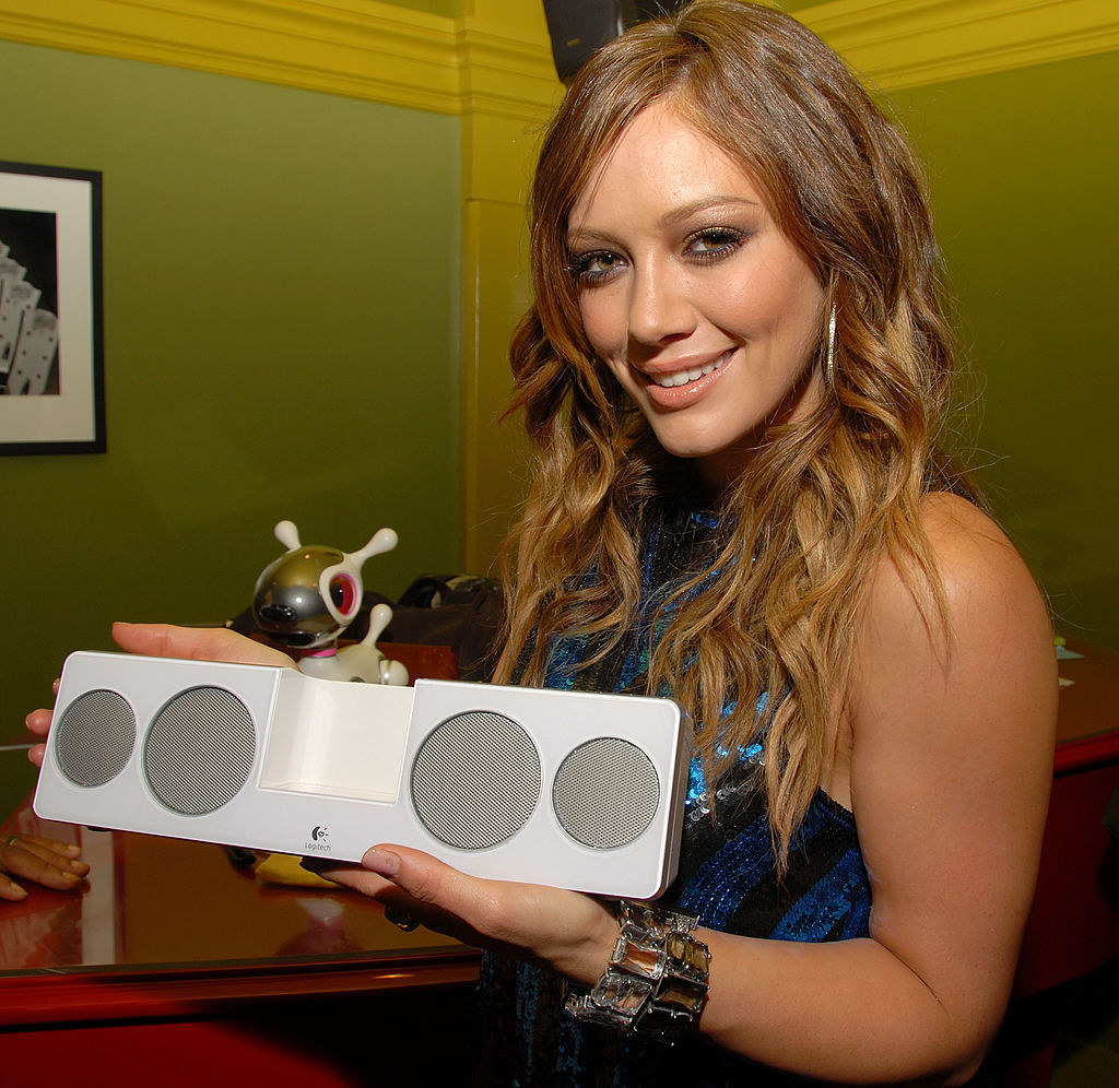 Hilary smiling and holding what looks like an iHome