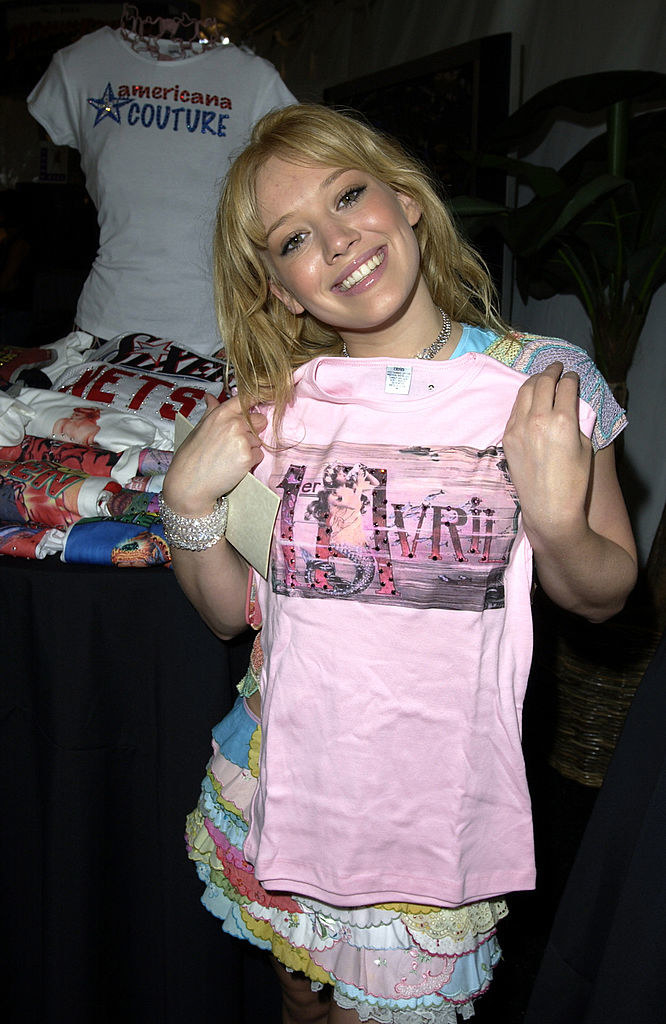 Hilary holding up a shirt with a design on it
