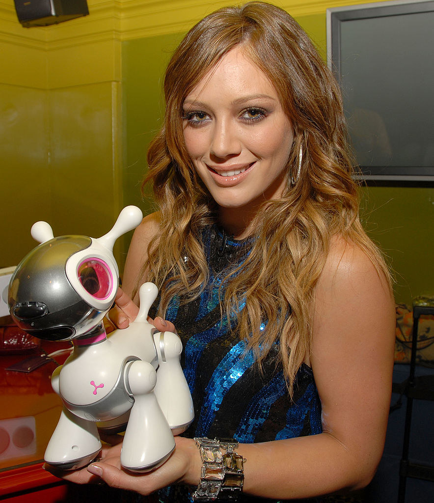 Hilary holding a large robot dog and smiling