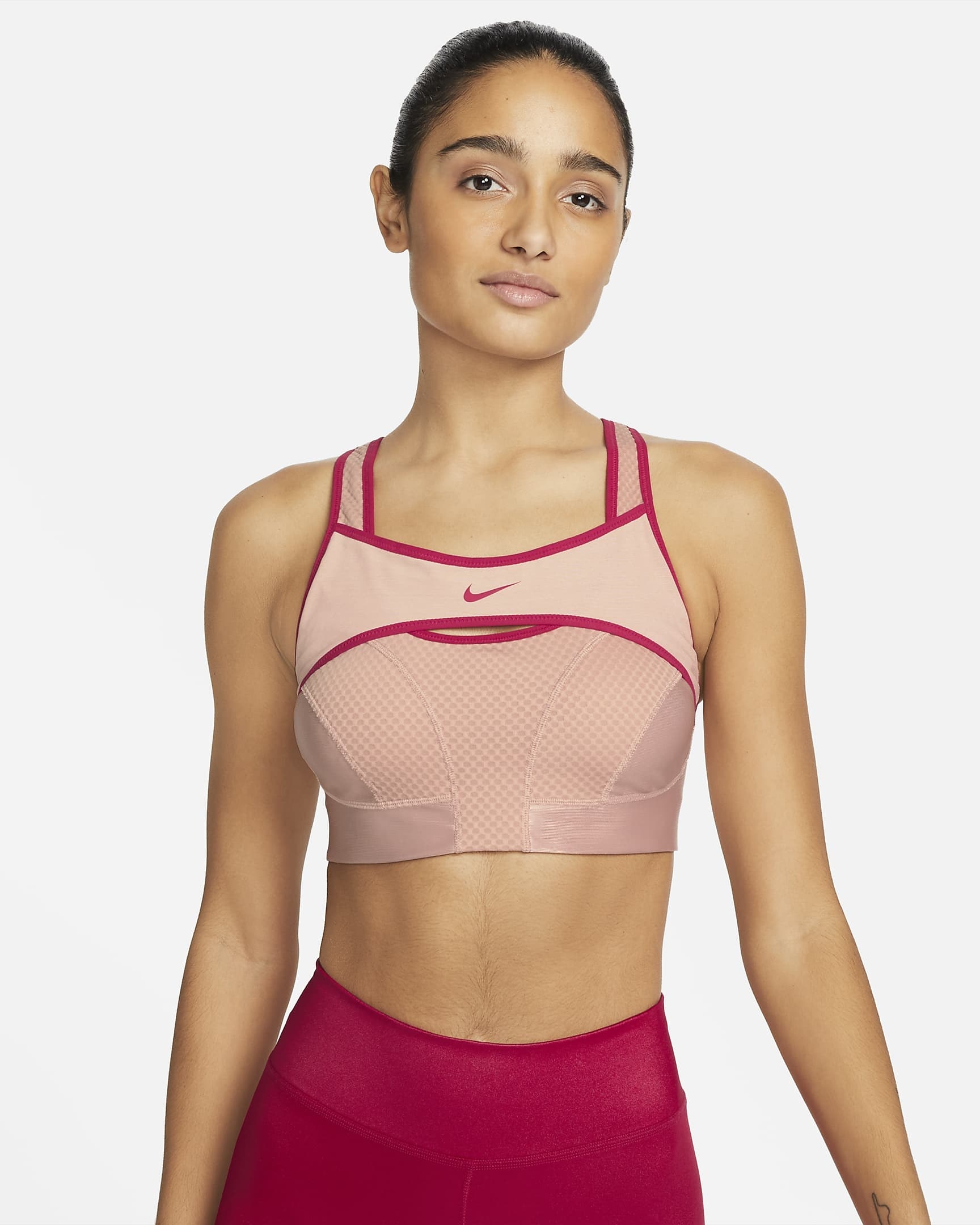 model in two-tone pink sports bra with an additional panel of fabric across the chest