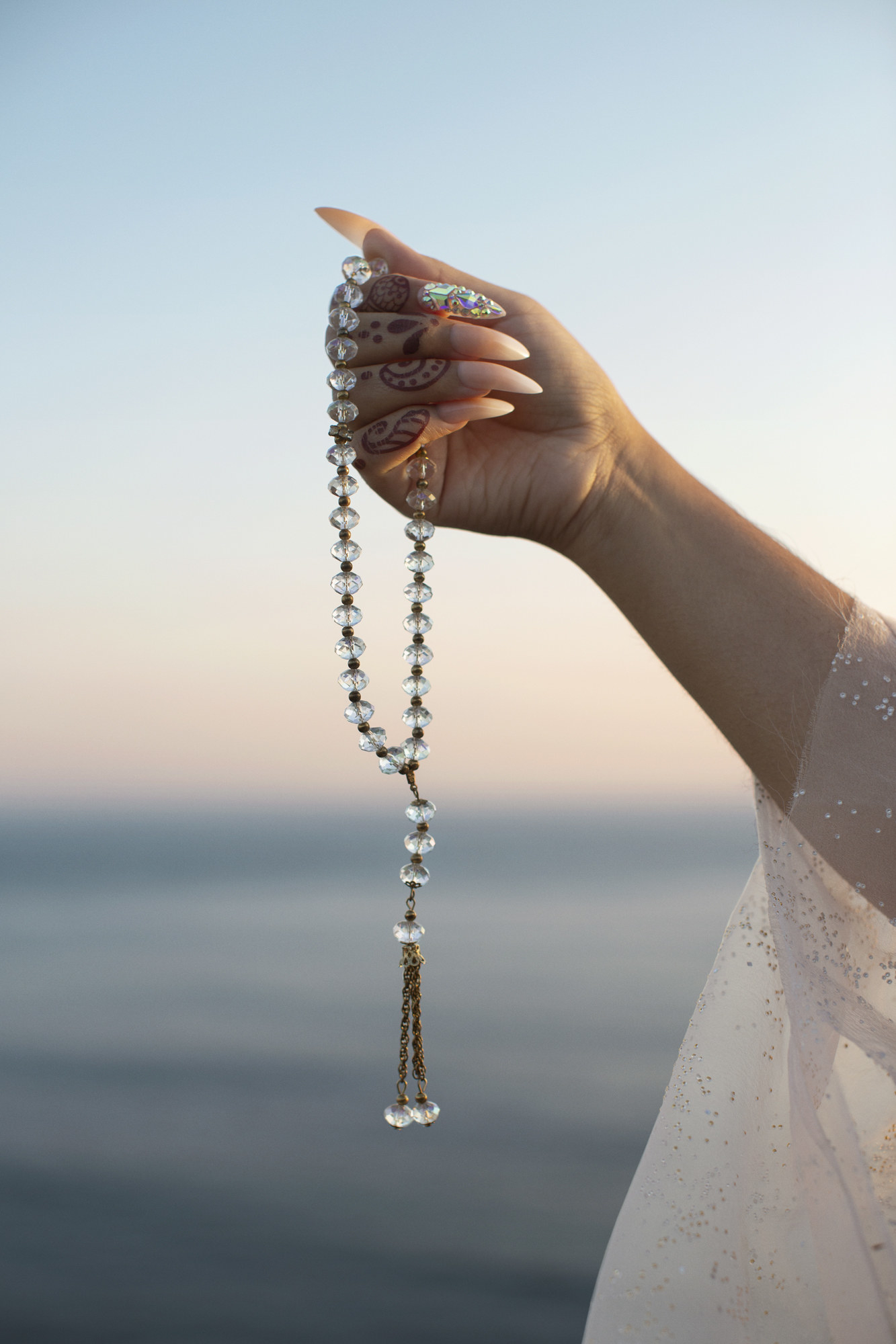 A woman&#x27;s hand holding a necklace