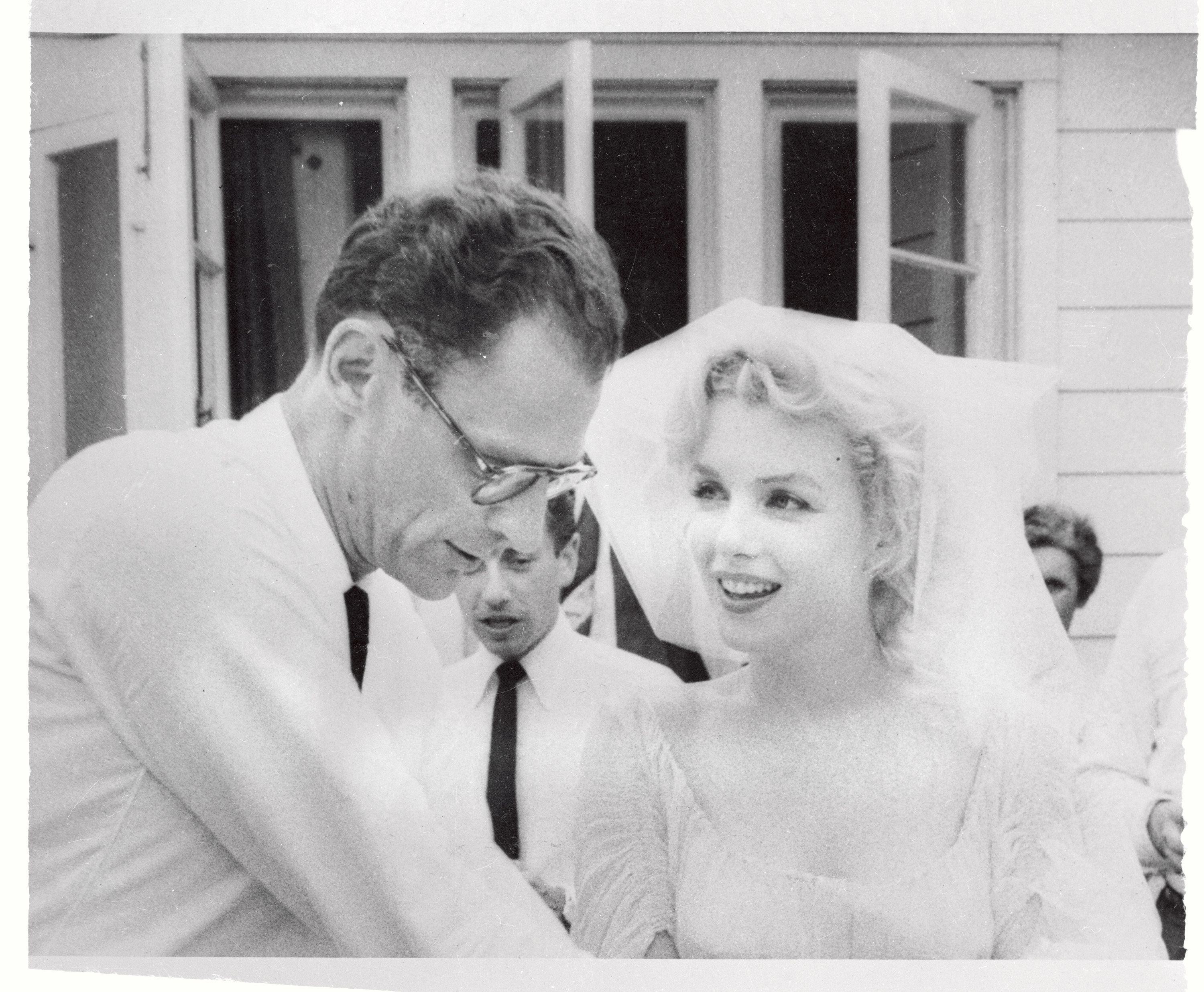 Arthur Miller and Marilyn Monroe stand outside together after their wedding ceremony