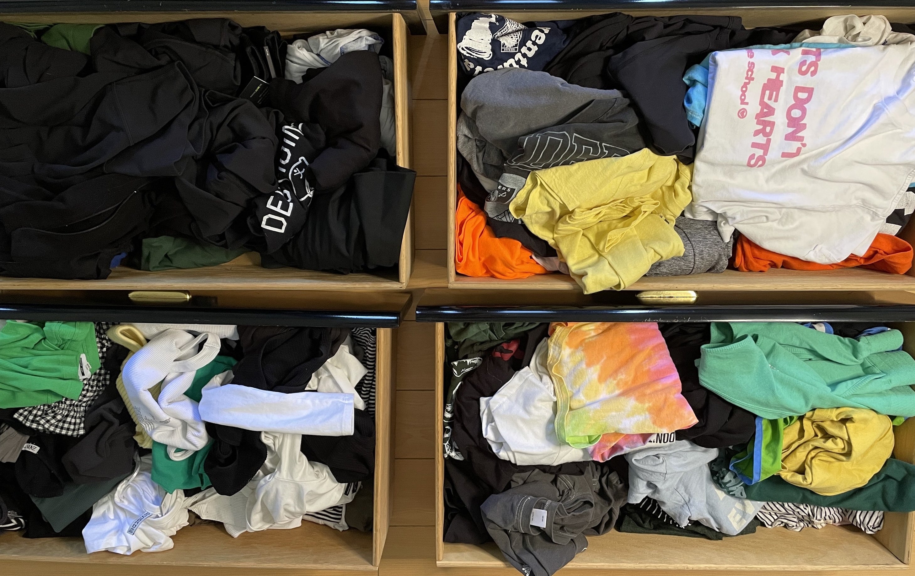 An aerial view of the four drawers sitting on the floor; they&#x27;re all disorganized, with different types and styles of clothing shoved together