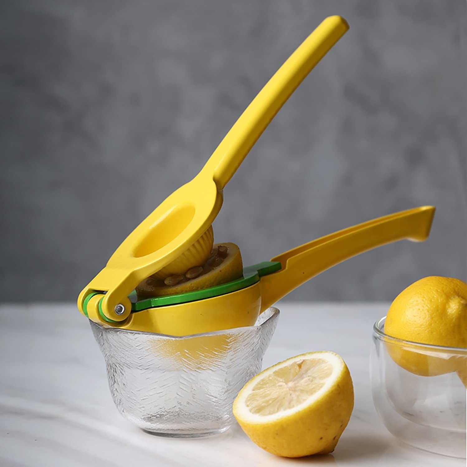 a juicer sitting on a small bowl next to lemons on a counter
