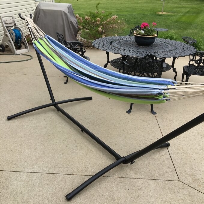 A blue and green hammock with a metal frame.