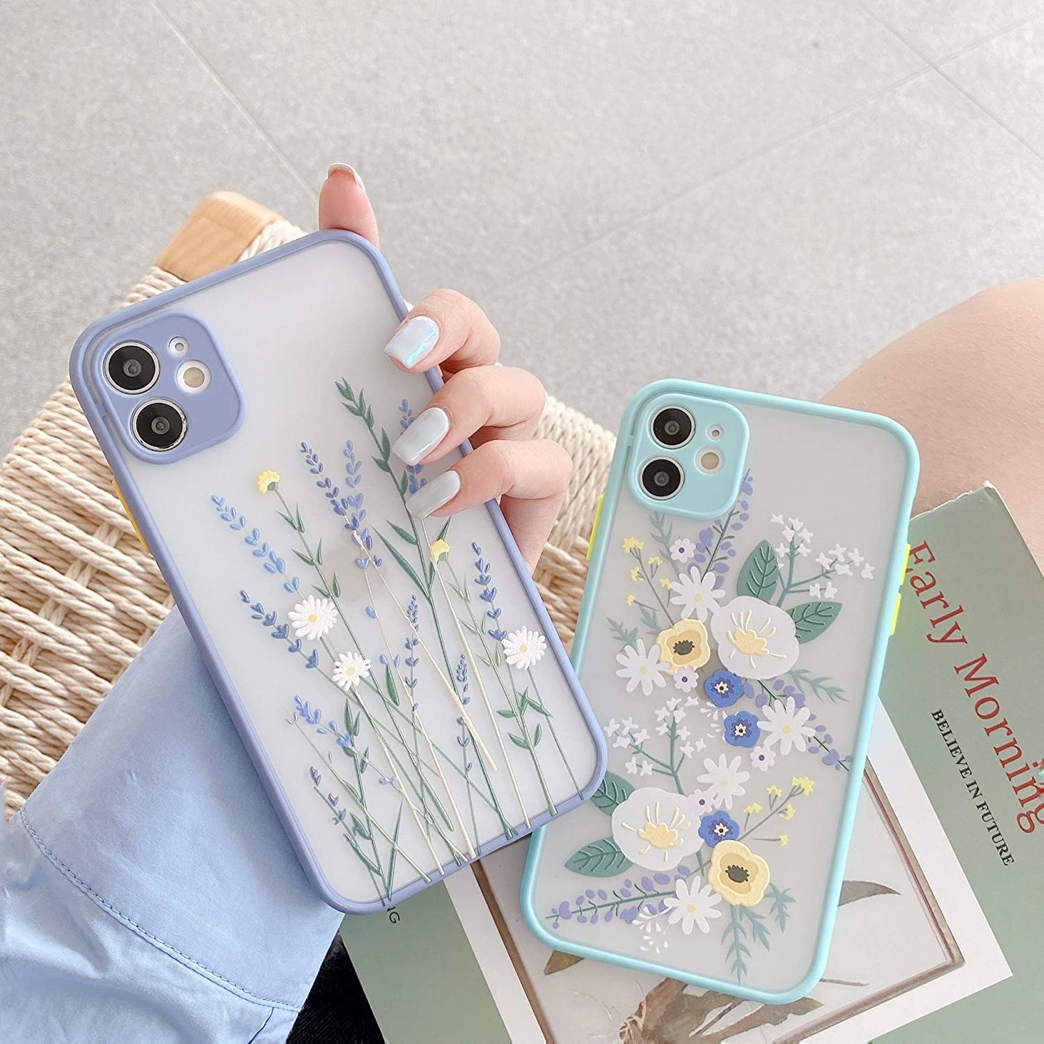 a person holding two floral phone cases