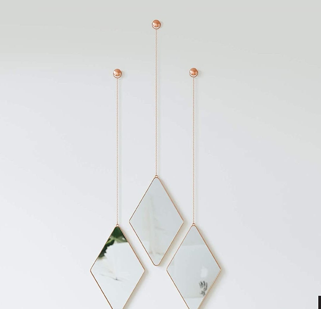 three diamond-shaped mirrors hanging on a wall